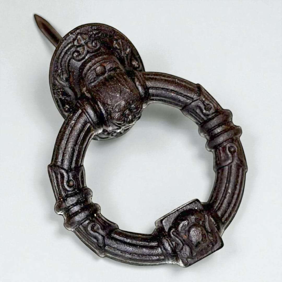 Vista lateral mostrando el relieve floral y el anillo macizo de la aldaba antigua.