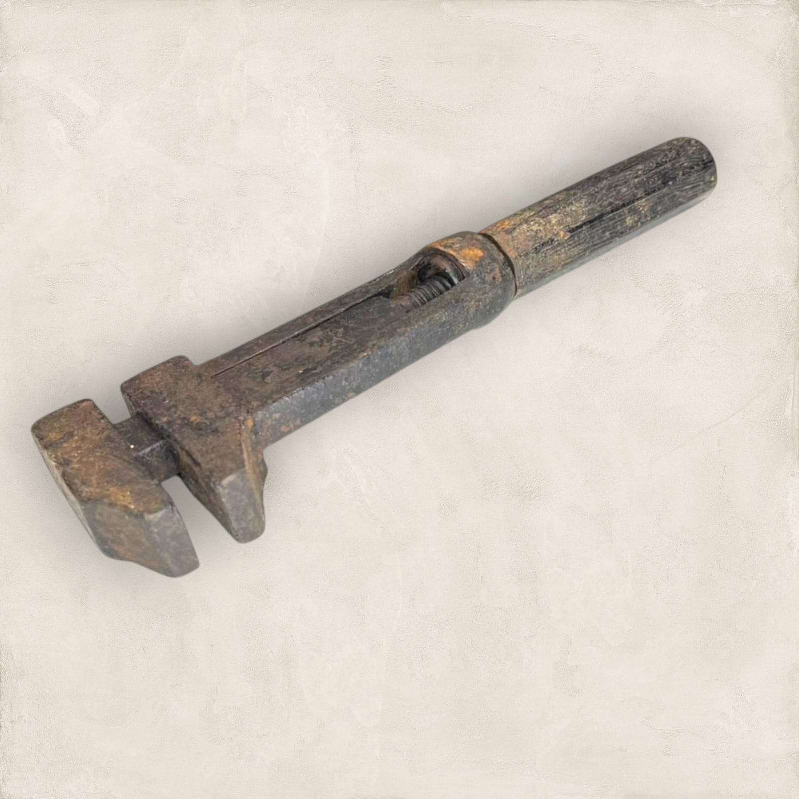 Llave inglesa antigua con sistema de rosca visible y mango hexagonal.