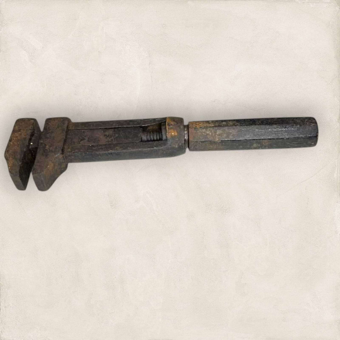 Llave inglesa antigua ajustable vista lateral con pátina metálica.
