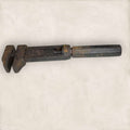 Llave inglesa antigua ajustable vista lateral con pátina metálica.