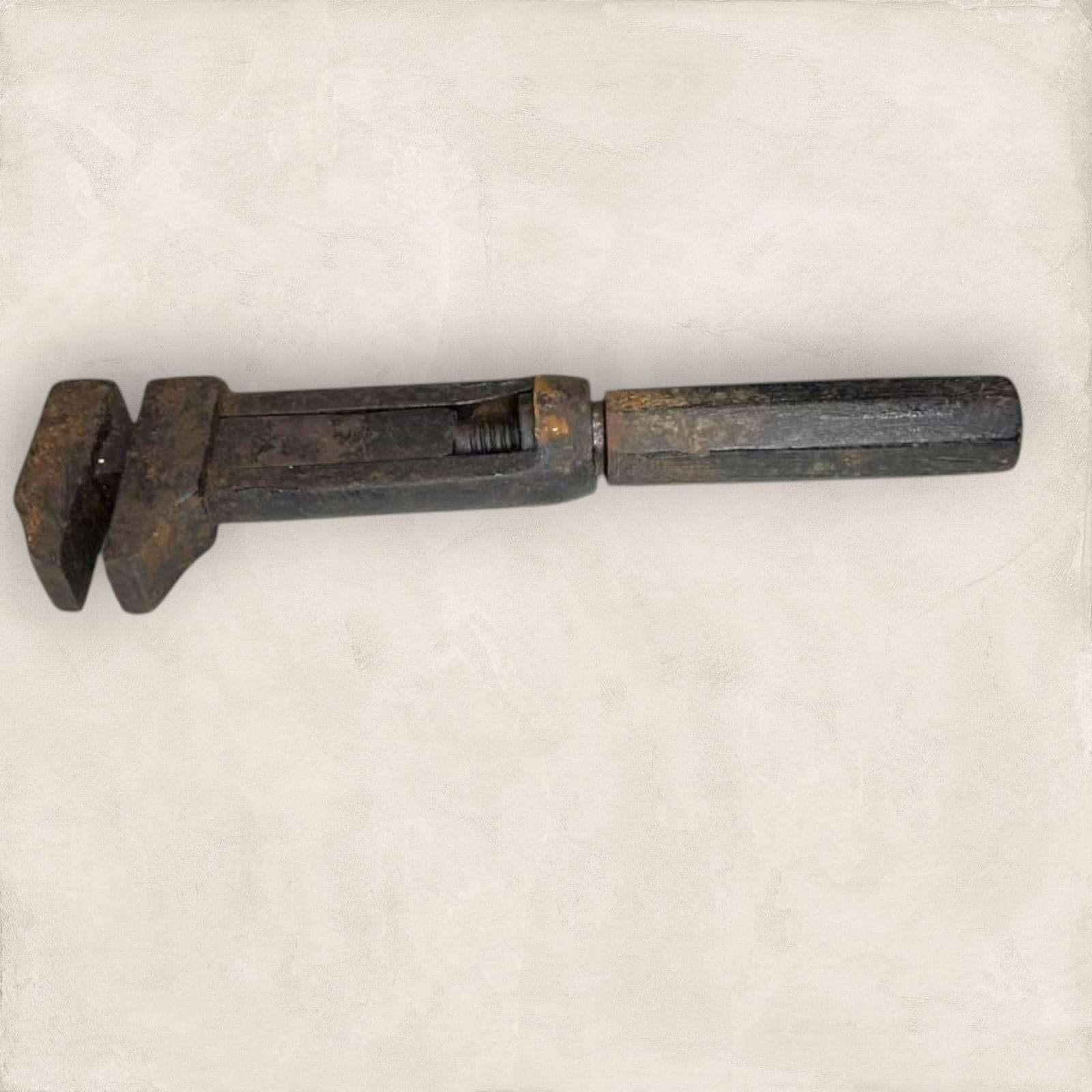 Llave inglesa antigua ajustable vista lateral con pátina metálica.