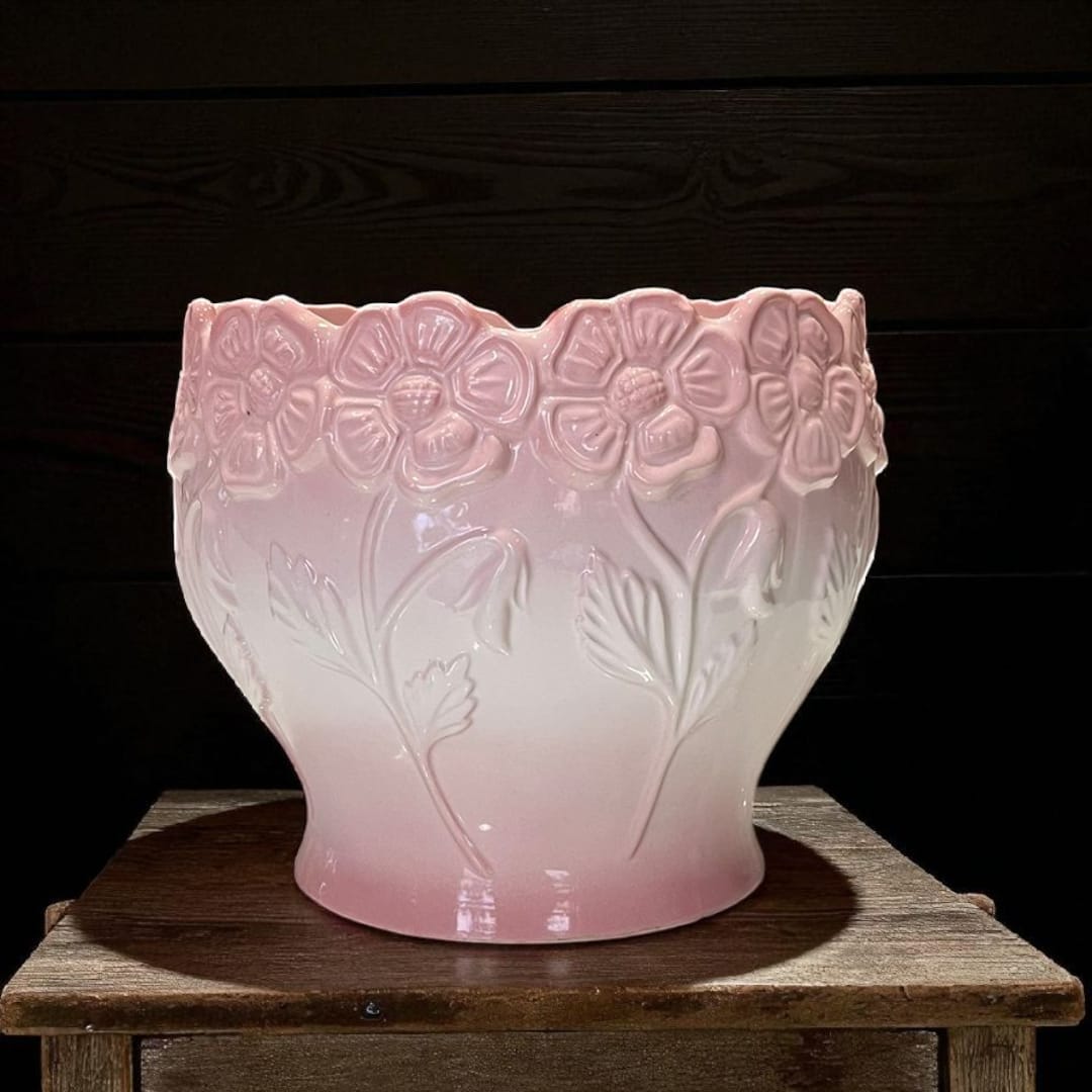 Macetero antiguo de porcelana colocado en taburete de madera.