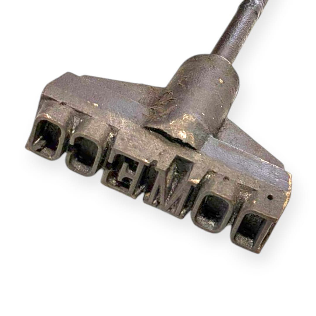 Marcador tonelero DOMECD en hierro forjado con letras en relieve, pieza única antigua para decoración vintage de bodegas o colecciones.
