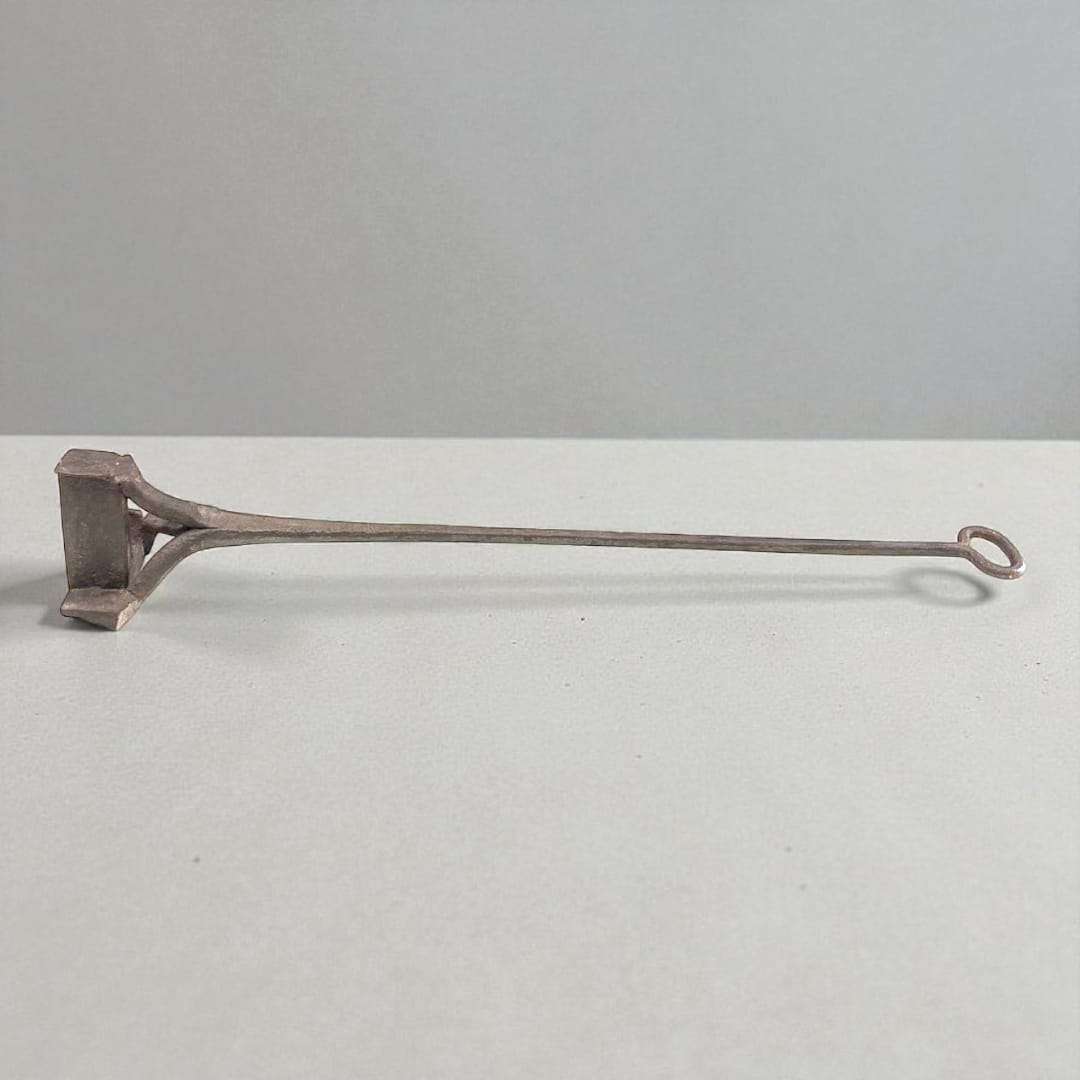 Marcador tonelero antiguo con letra L visto en perspectiva frontal.