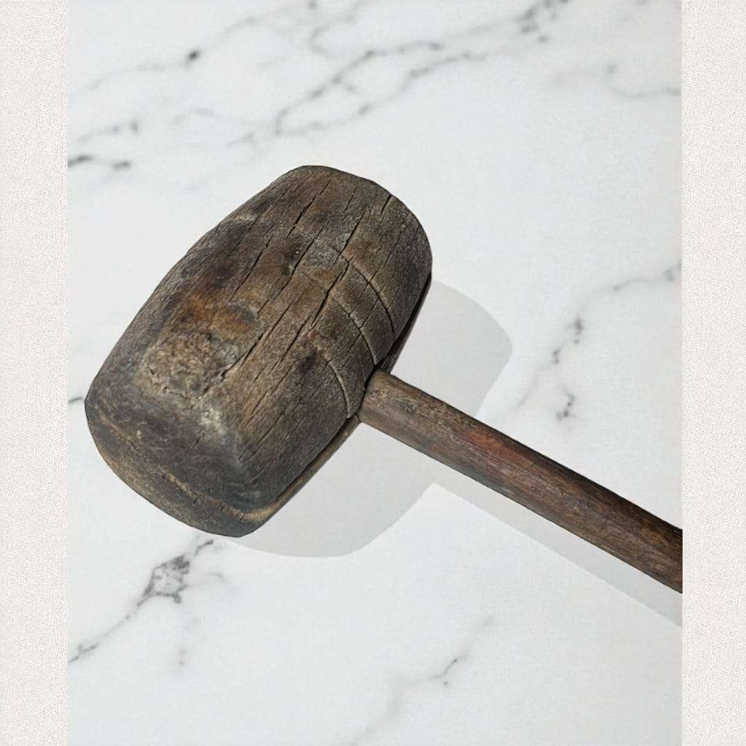 Detalle de la cabeza del mazo de madera antiguo con desgaste natural.