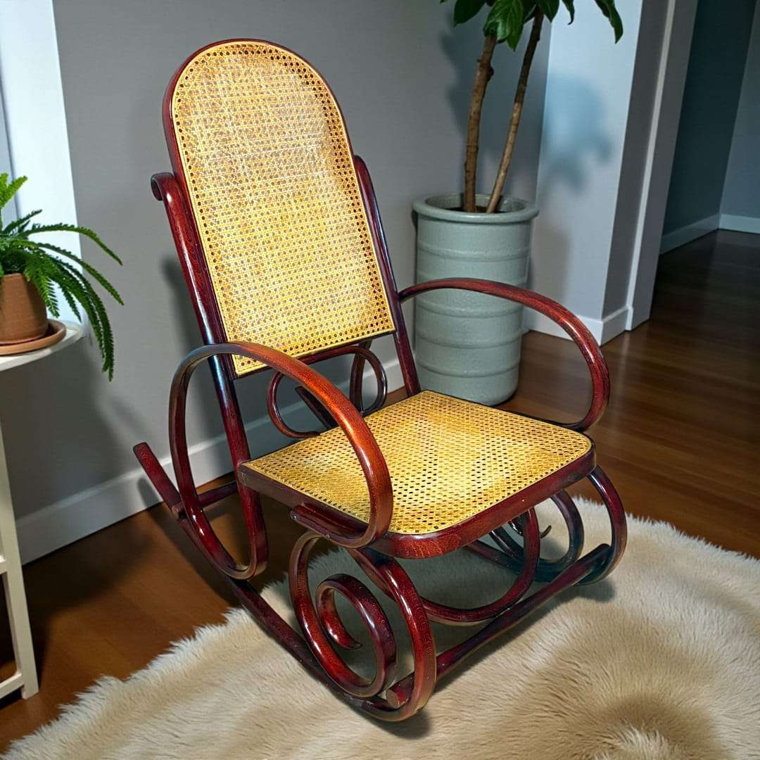 Mecedora de madera y rejilla natural en interior clásico.