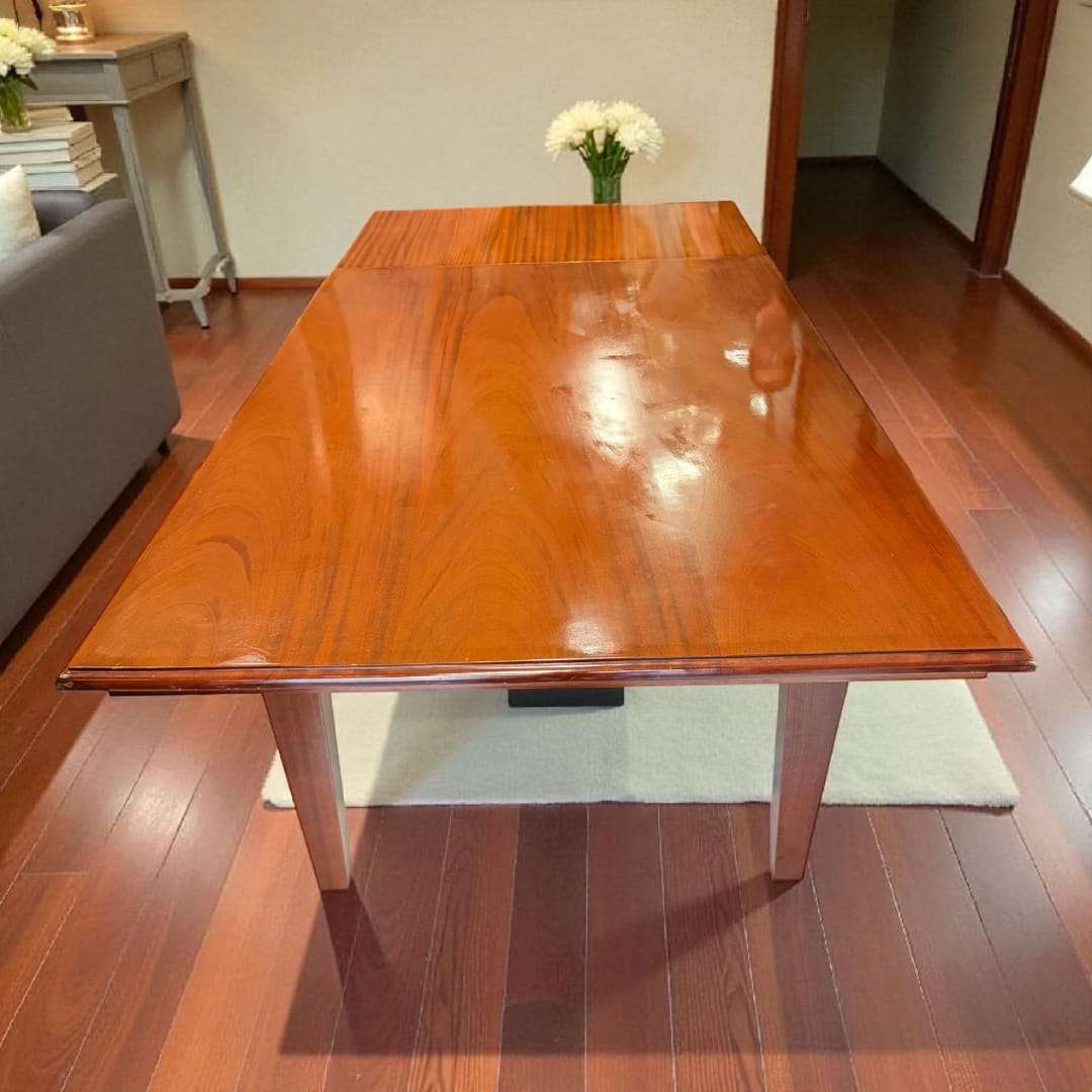 Mesa de comedor de caoba extensible con superficie brillante.
