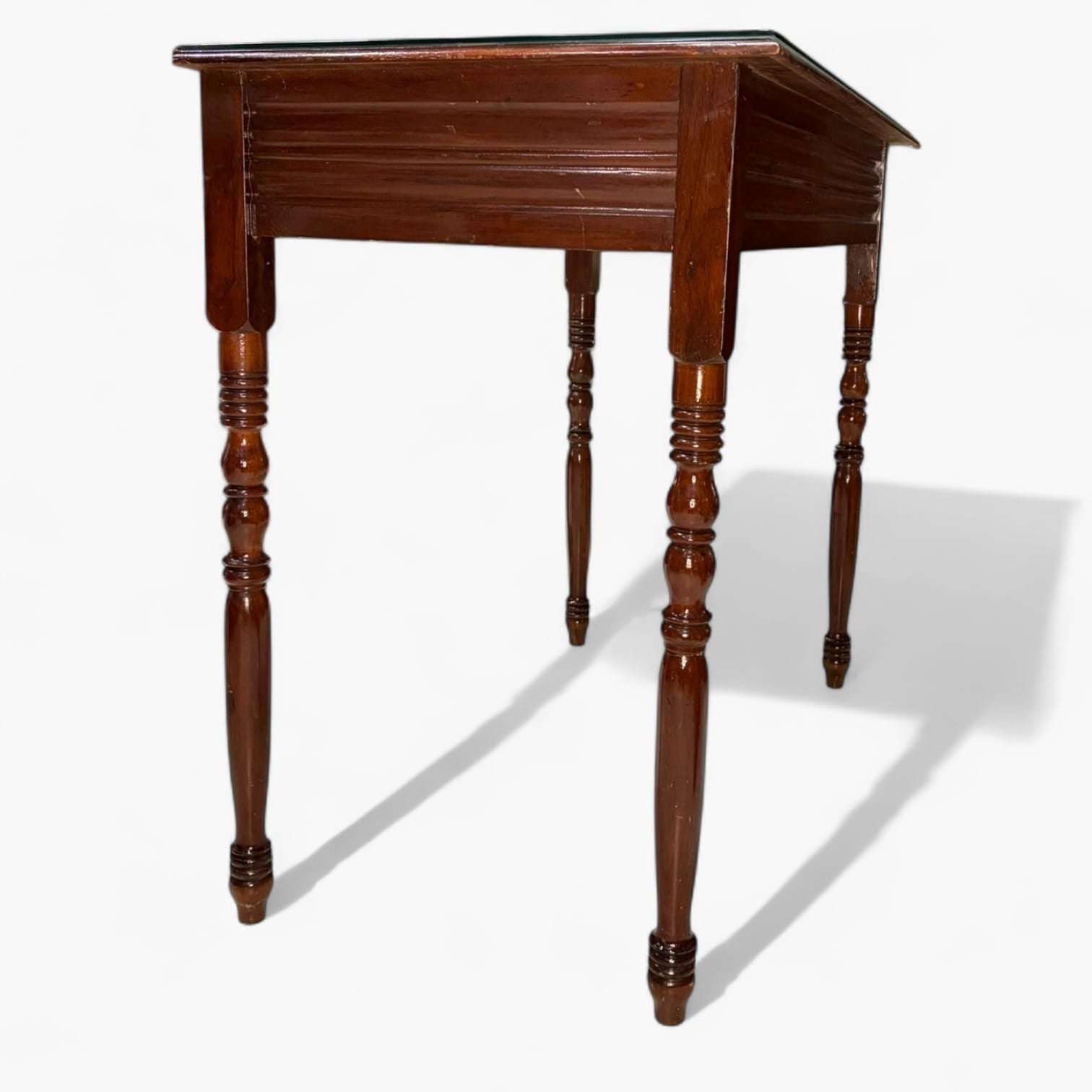 Esta mesa de caoba con tapa de cristal antigua rectangular fue concebida originalmente como mesa auxiliar o de apoyo en salones distinguidos, despachos o zonas de recibidor.