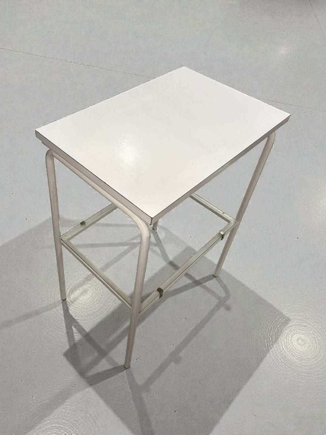 Mesa auxiliar blanca vintage con balda de cristal vista en ángulo frontal.