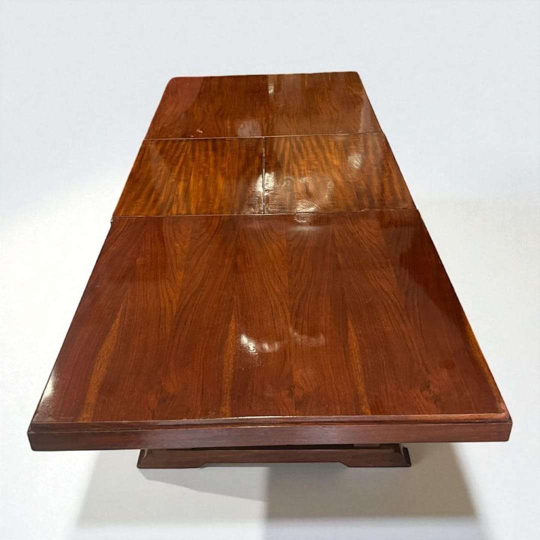 Mesa comedor extensible de caoba con acabado brillante.