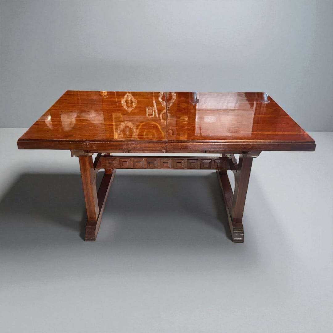 Mesa comedor extensible de caoba con acabado brillante.