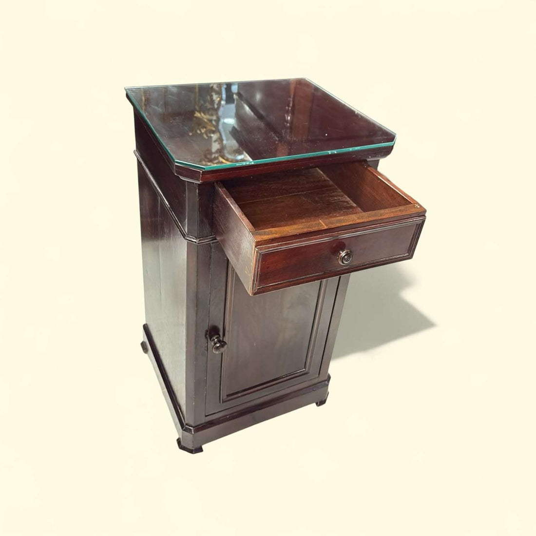 Mesa de noche de madera antigua con tapa de cristal vista frontal