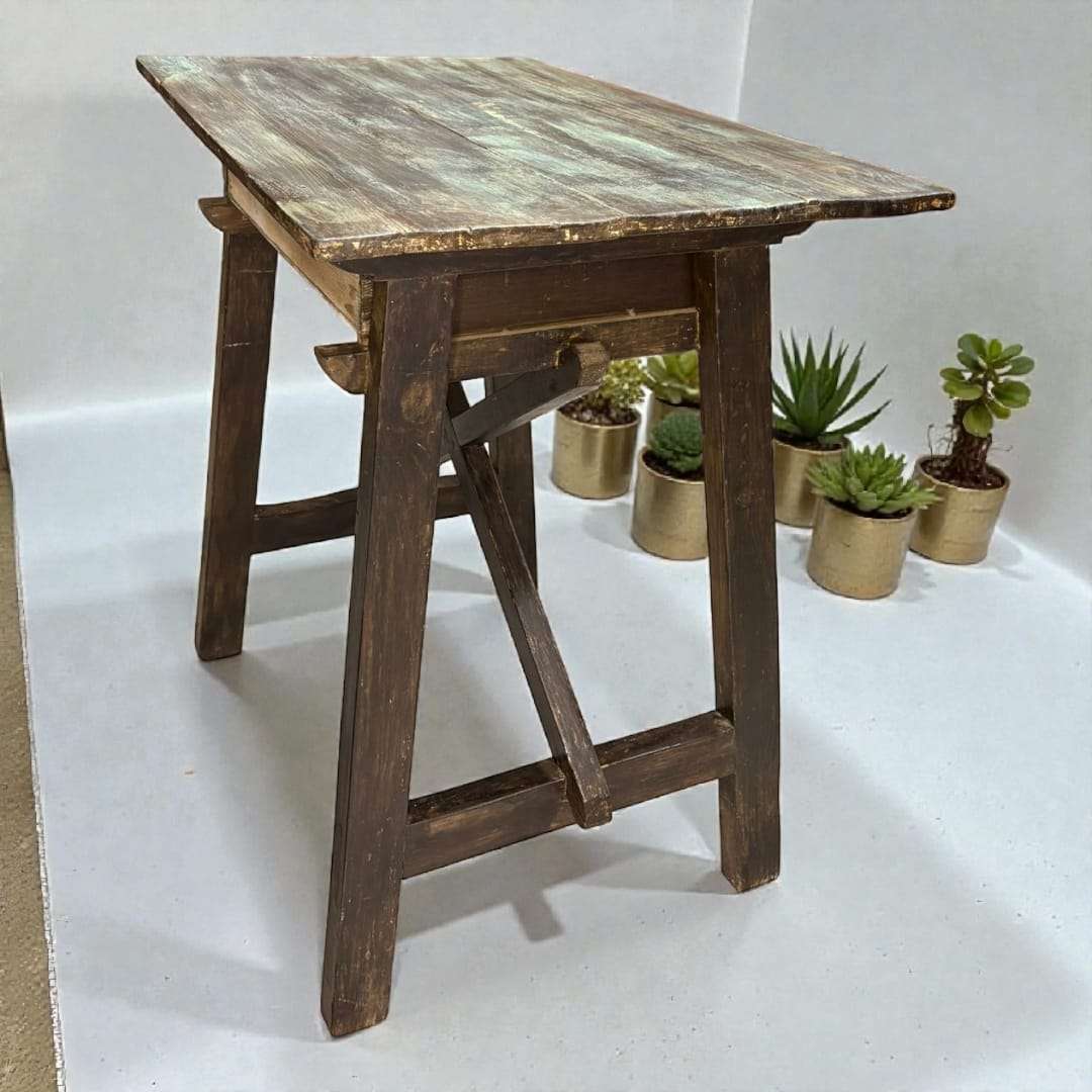 Vista lateral de la mesa tocinera antigua con estructura en X.