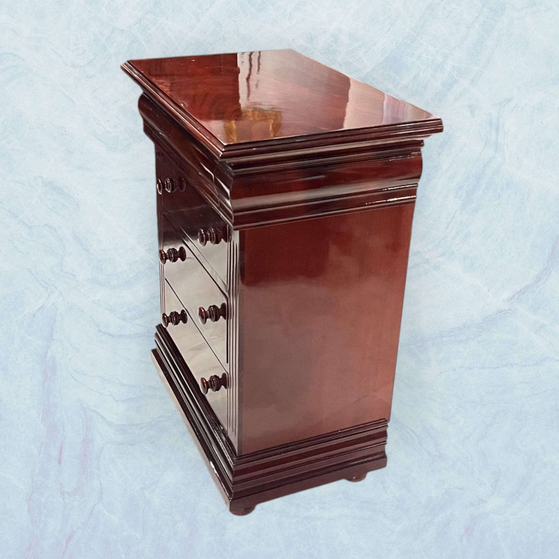 Mesita de noche de caoba con acabado brillante, tres cajones y diseño clásico. Ideal para decoración elegante en dormitorio.