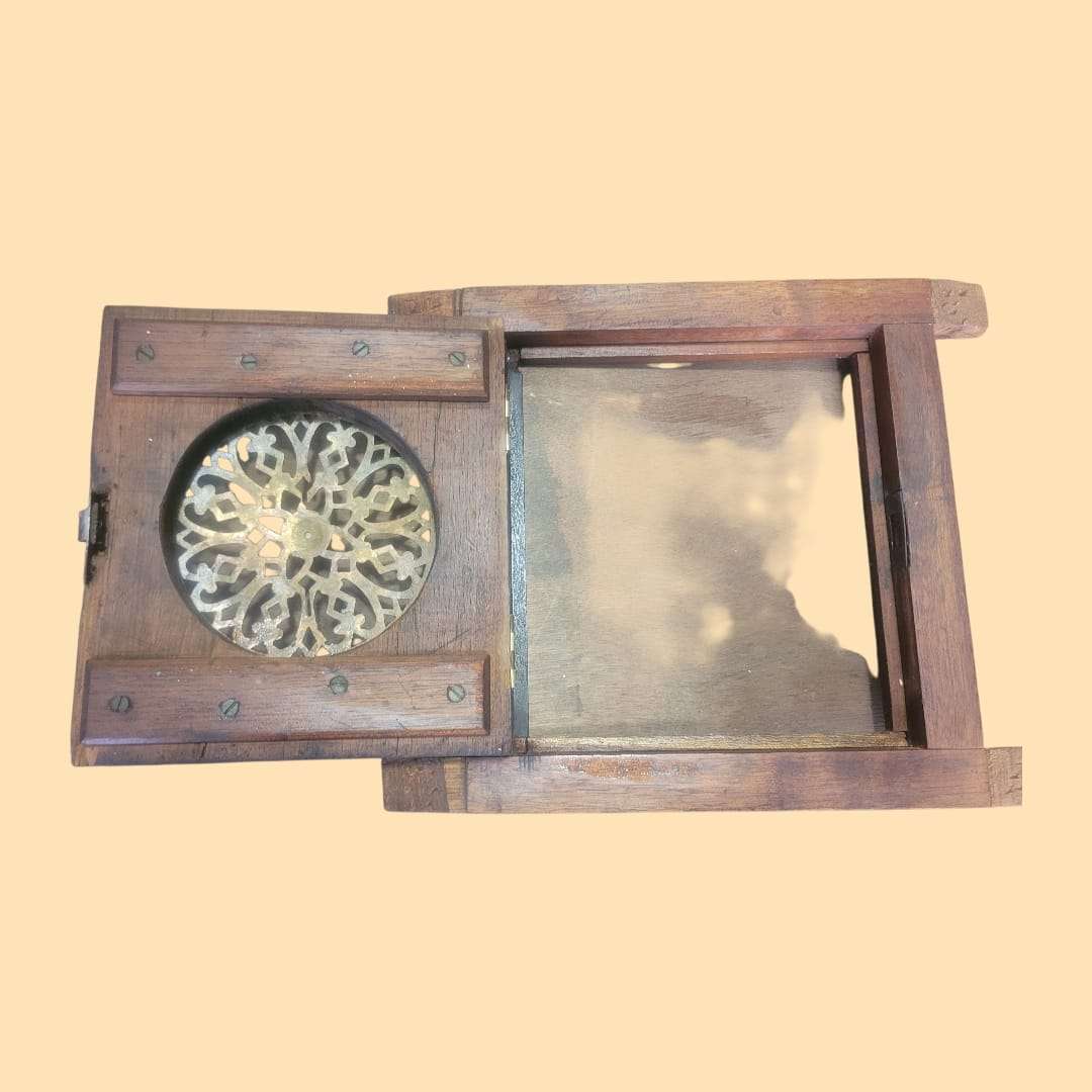 Mirilla antigua abierta mostrando interior de madera y diseño calado en metal dorado, ideal para decoración auténtica de interiores.