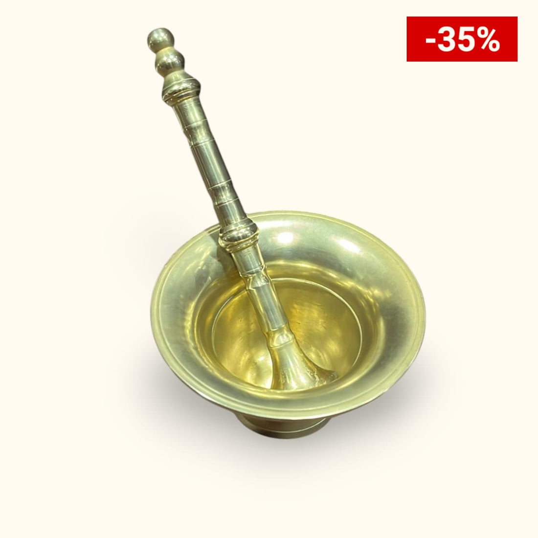 Mortero de bronce con maja antigua sobre superficie de madera, ideal para decoración vintage o cocina tradicional. Diseño único y calidad superior.