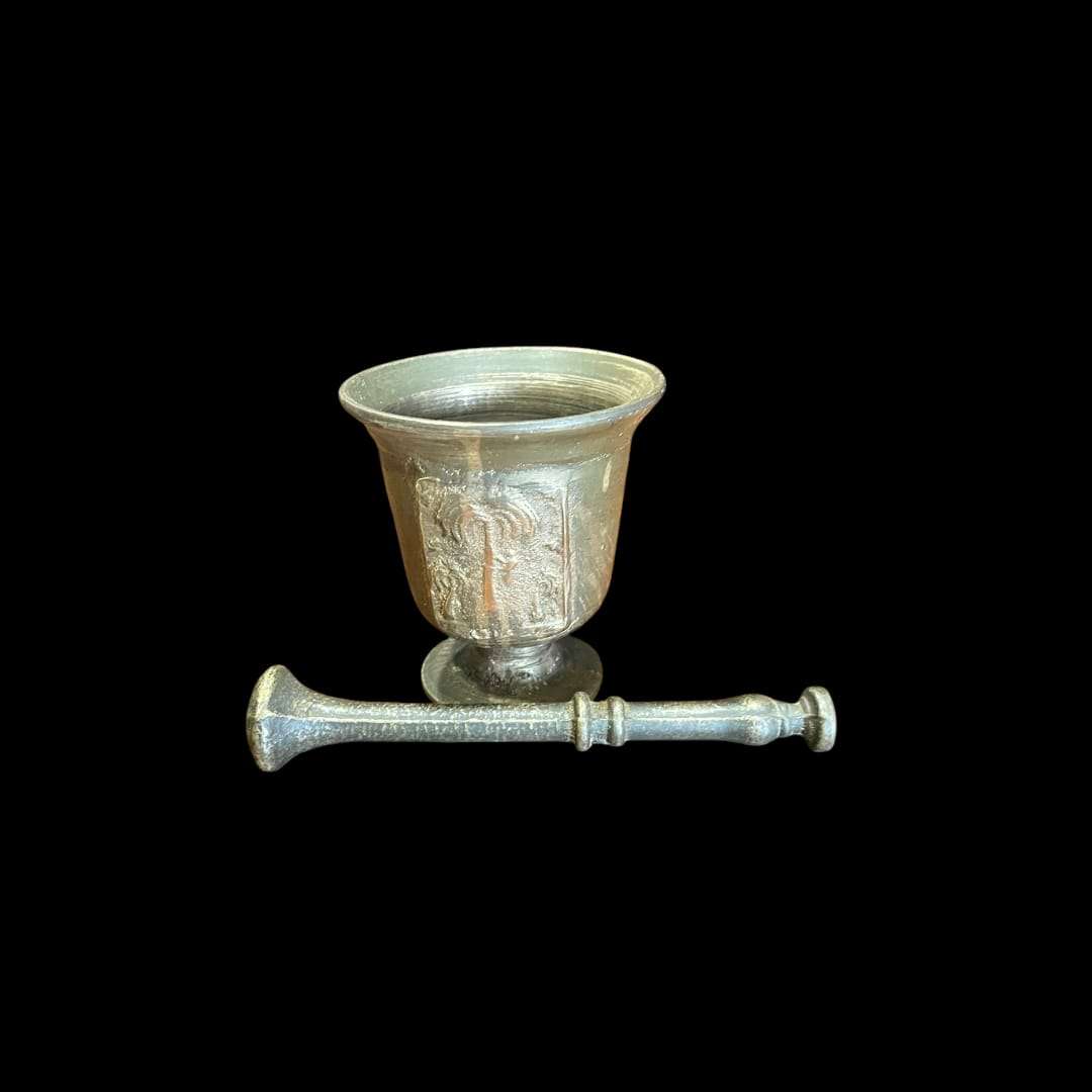 Mortero de bronce antiguo con relieve decorativo y maja incluida.