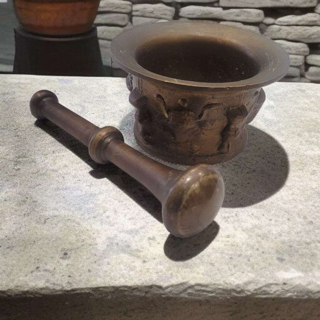 Mortero de bronce envejecido con detalles artesanales y maja clásica. Perfecto para decoración de cocina o jardín con estilo antiguo.