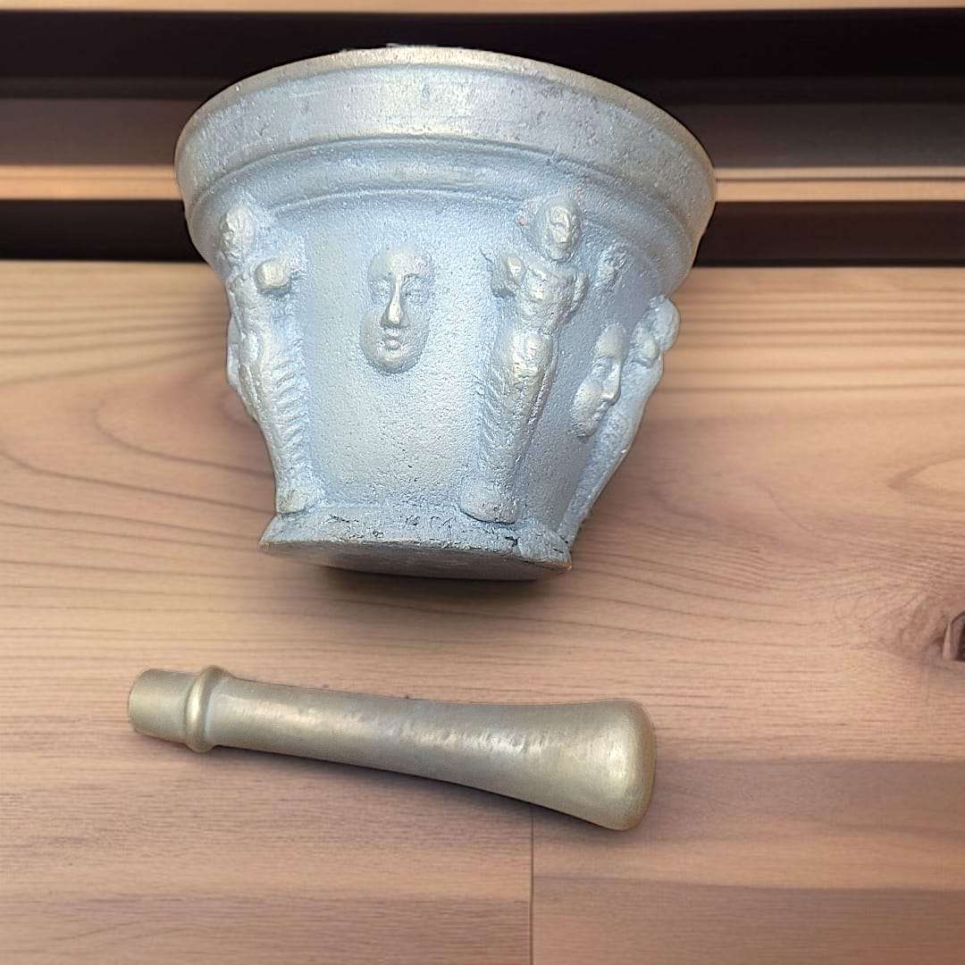 Mortero antiguo de bronce con relieves figurativos y maja única, ideal para decoración vintage en el hogar o jardín. Pieza decorativa con acabado envejecido.