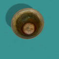 Mortero antiguo de bronce visto desde arriba, con pátina natural y marcas de uso. Decoración vintage ideal para coleccionistas de objetos únicos.