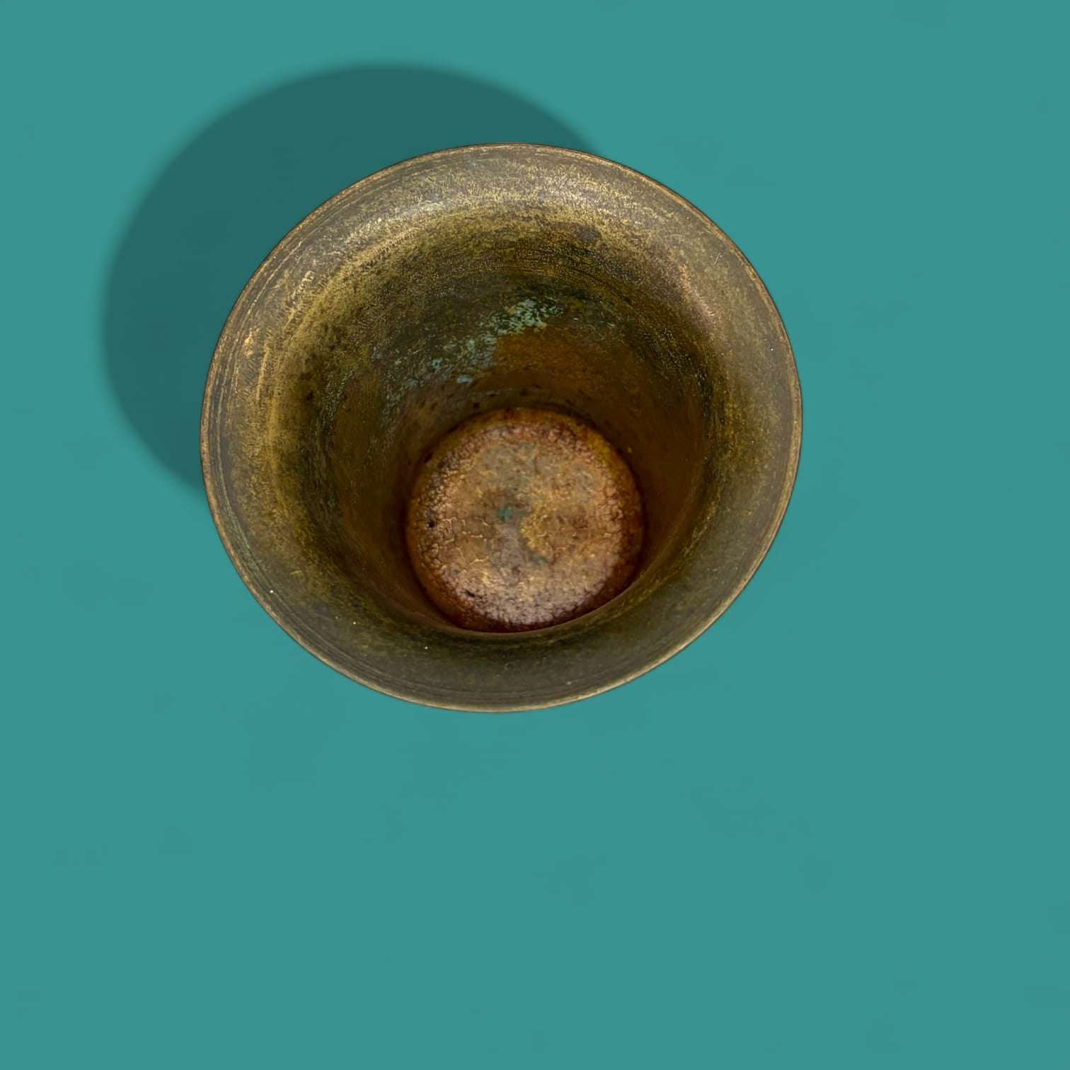 Mortero antiguo de bronce visto desde arriba, con pátina natural y marcas de uso. Decoración vintage ideal para coleccionistas de objetos únicos.