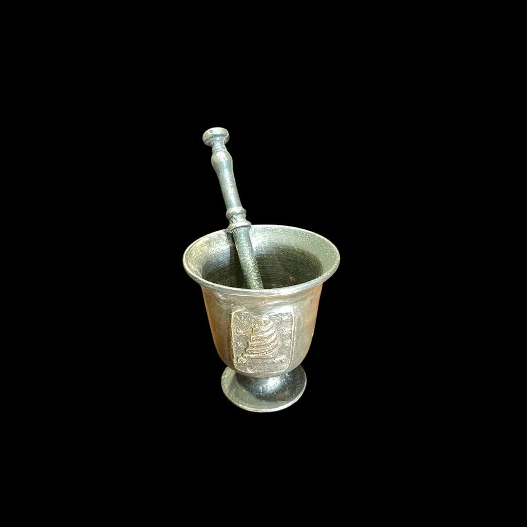 Mortero de bronce antiguo con relieves artísticos en sus paredes.