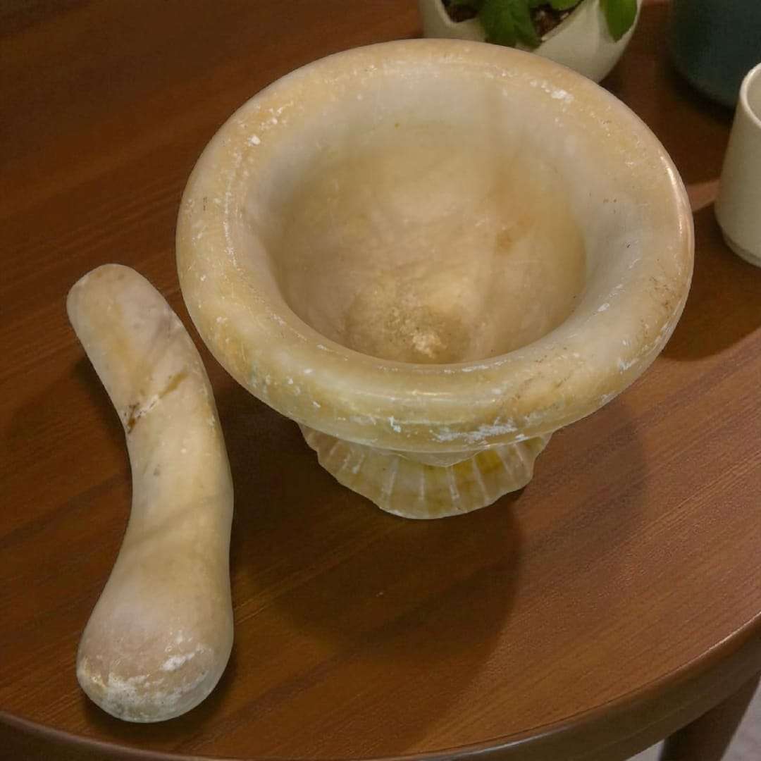 Mortero de alabastro antiguo sin la maja colocada, mostrando su interior pulido. Perfecto para decoración tradicional o uso culinario.