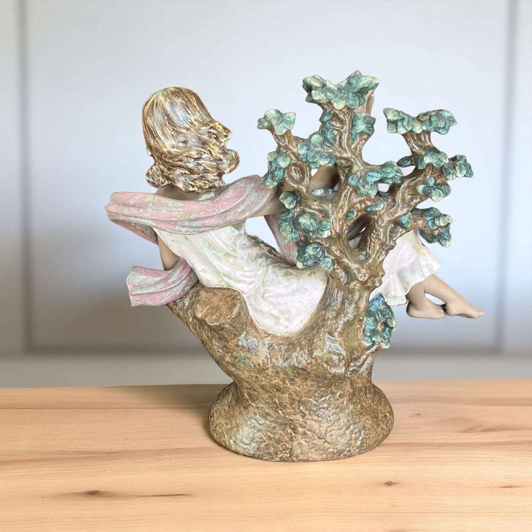 Parte trasera de la escultura Day Dream de Lladró mostrando detalle del cabello y árbol.

