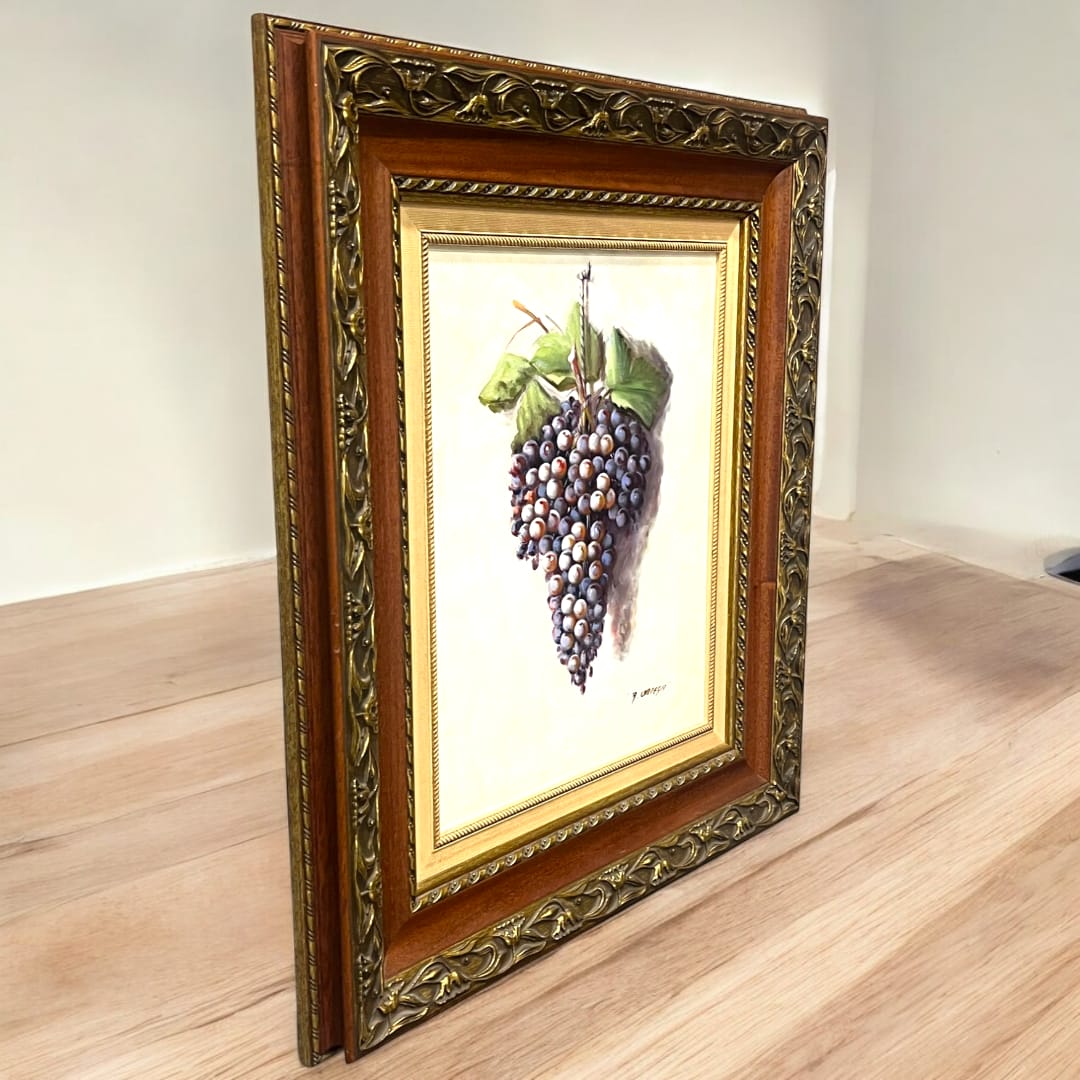 Pareja de óleos con racimos de uvas, firmados por Manuel Ruiz Ortega. Elegantes marcos dorados con detalles ornamentales, ideales para decoración.