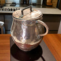 Olla de cobre antigua martilleada con tapa y asas, ideal para decoración rústica en cocinas tradicionales o colecciones vintage.