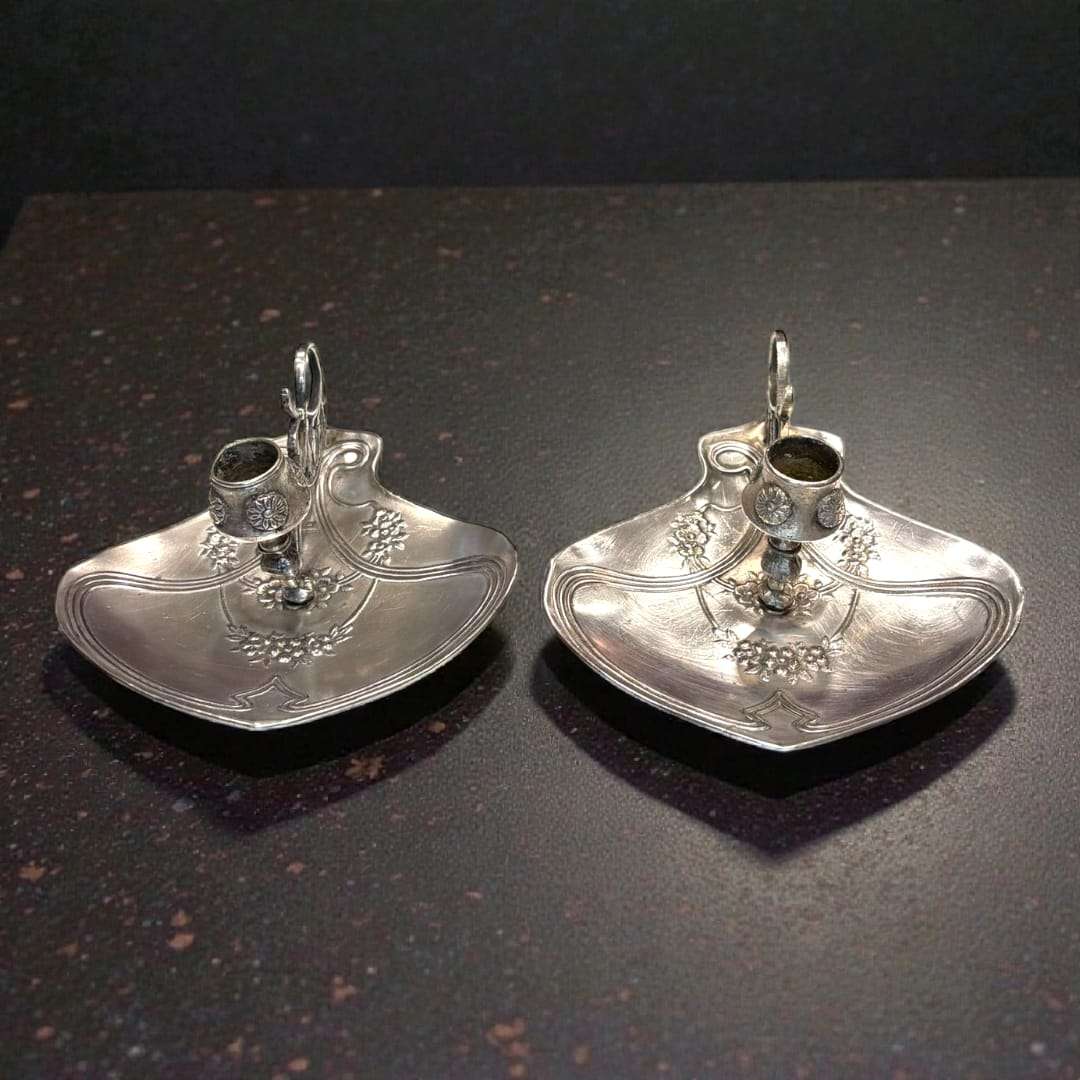 Palmatoria modernista Meneses en metal plateado con relieves florales y asa calada, estilo art nouveau. Decoración exclusiva para el hogar.