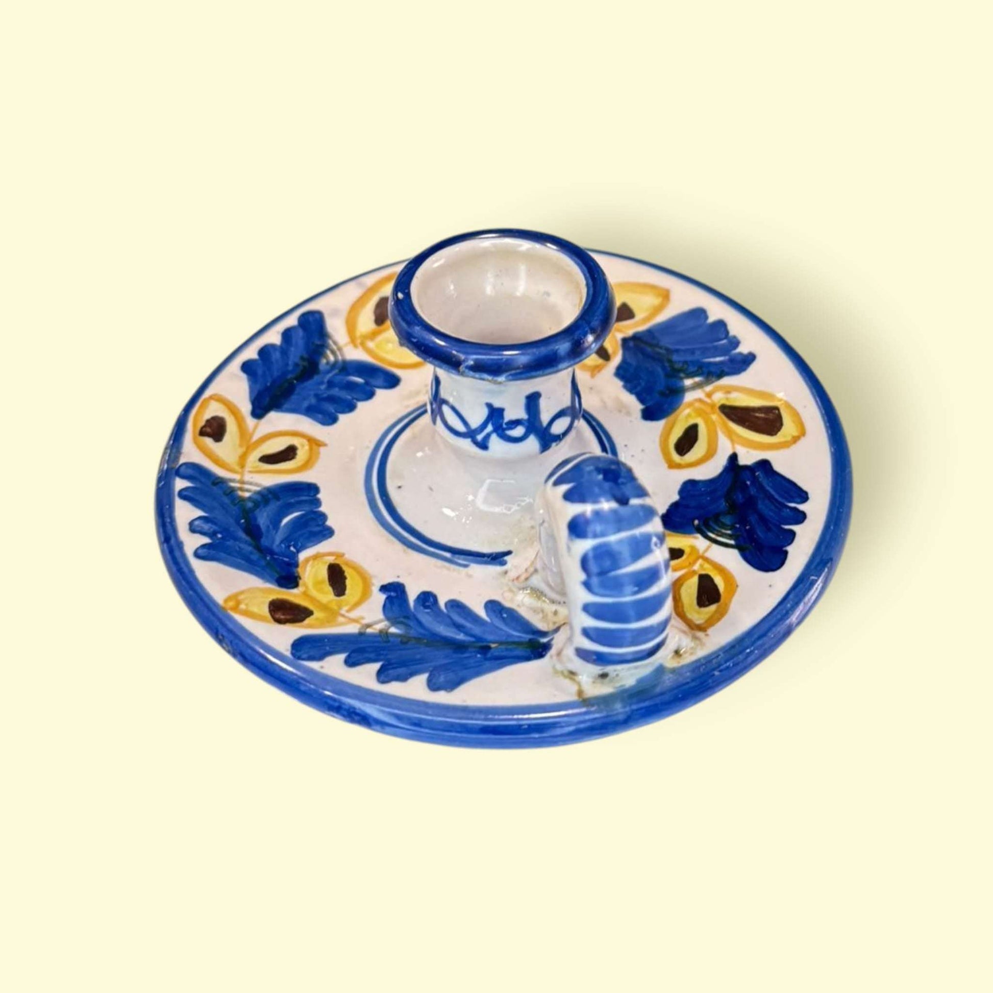 La Palmatoria de cerámica conserva a la perfección su función original, pudiendo usarse como portavelas o como pieza puramente decorativa en ambientes rústicos, vintage o mediterráneos.