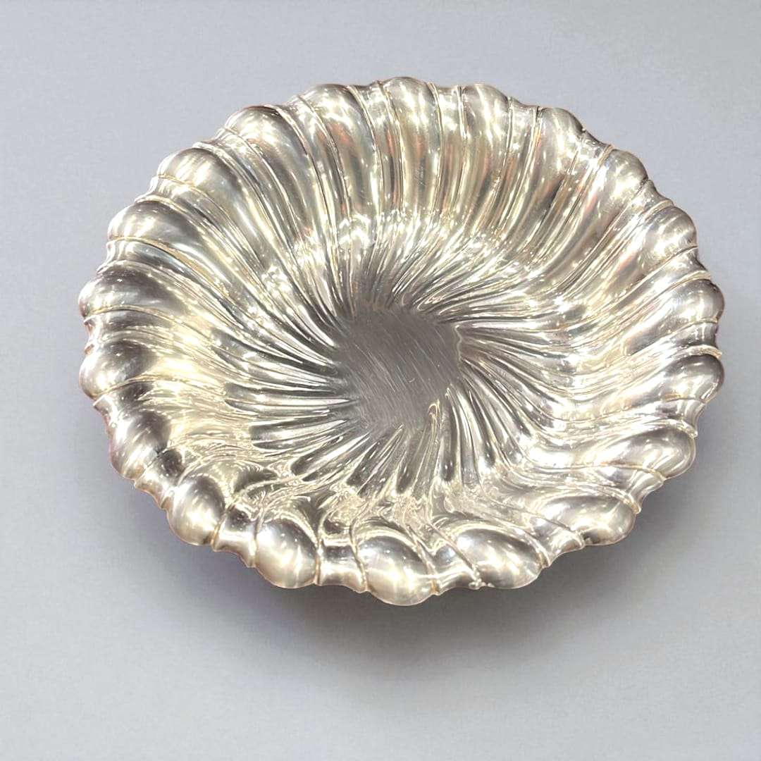 Panera de metal plateado con diseño ondulado y acabado brillante.