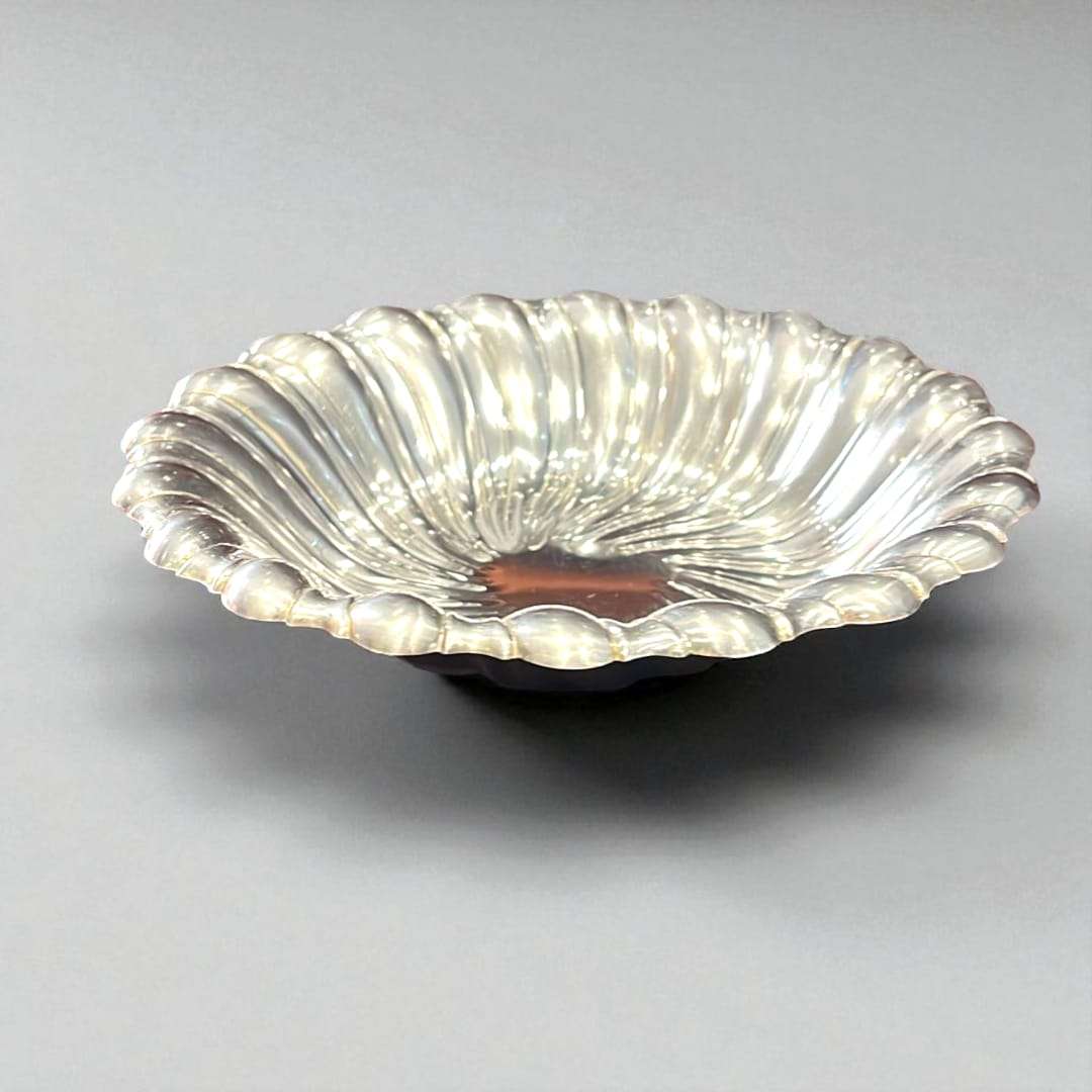 Vista lateral de la panera plateada, mostrando su forma elegante.