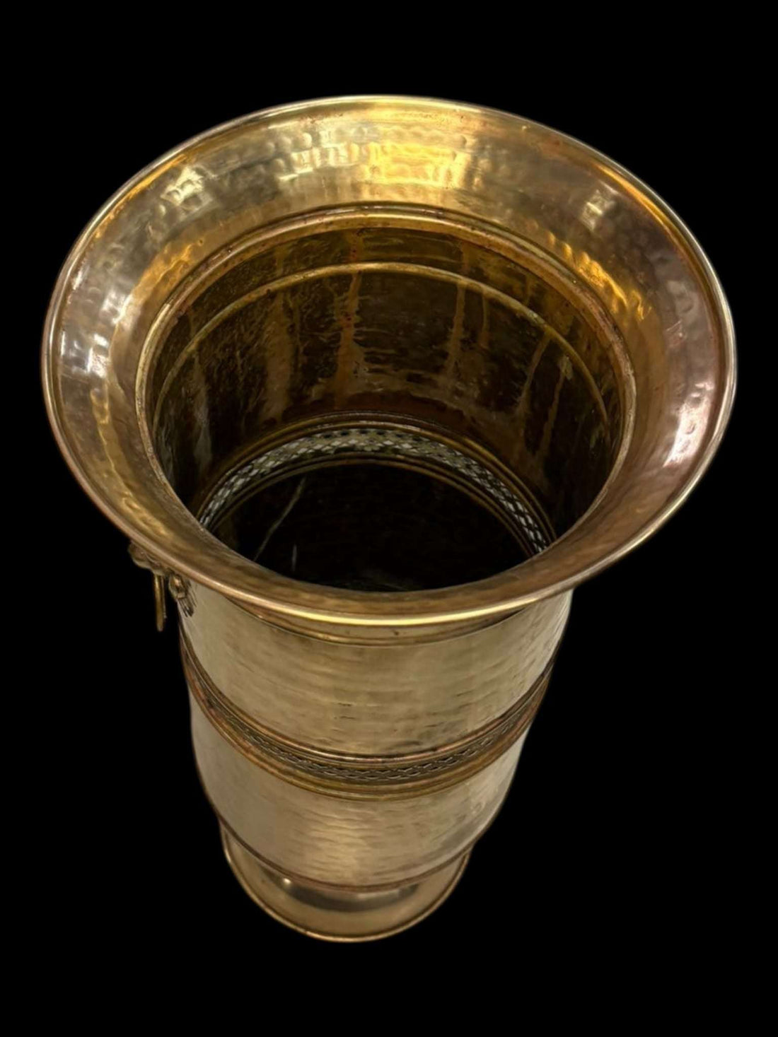 Paraguero metálico dorado con asas de león estilo clásico, acabado martillado y diseño elegante para decoración de entradas. Ideal para interiores sofisticados.