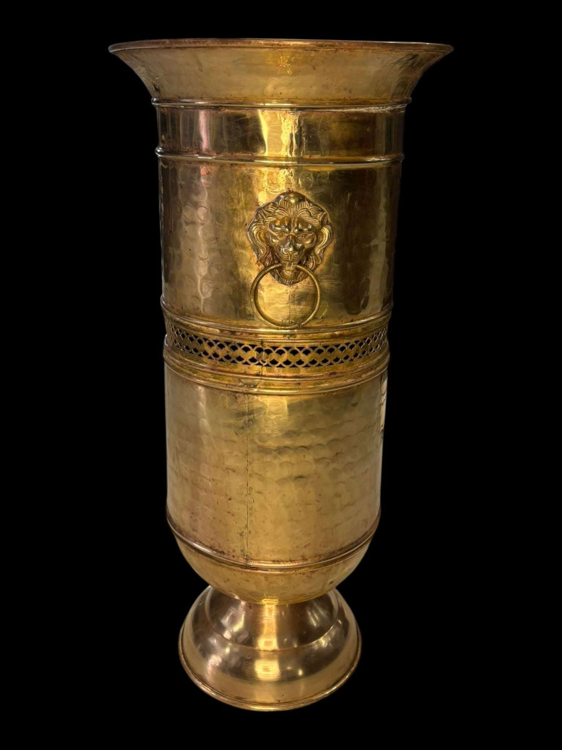 Paraguero metálico dorado con asas de león estilo clásico, acabado martillado y diseño elegante para decoración de entradas. Ideal para interiores sofisticados.