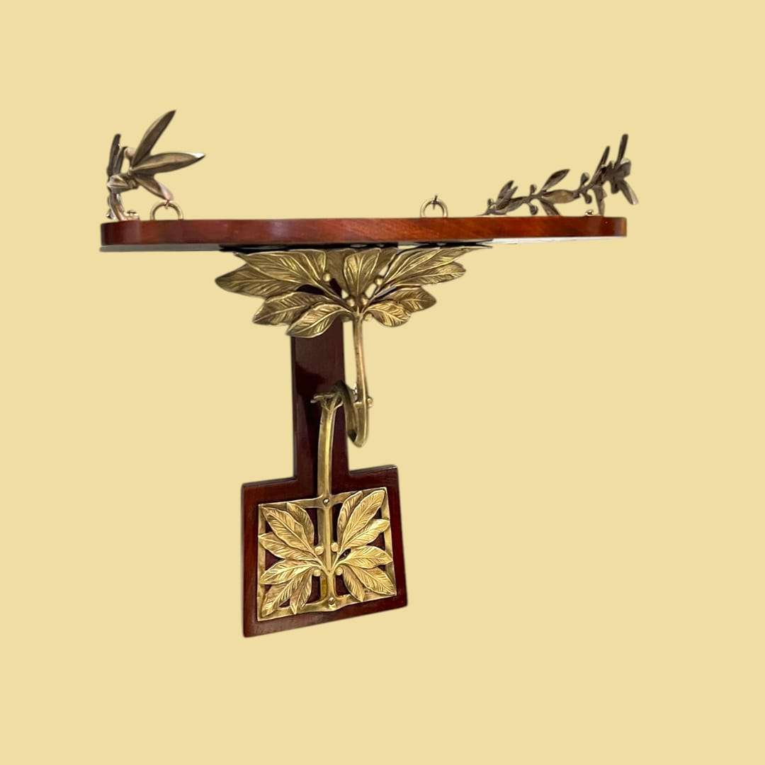 Ménsula estilo Art Decó de madera y metal con hojas ornamentales.