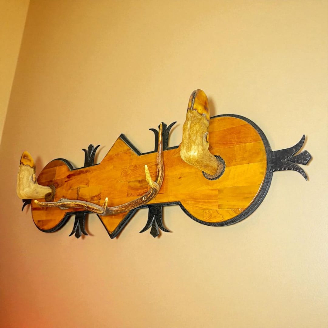 Perchero rústico de cazador en madera y hierro con cuernos de ciervo, ideal para decoración vintage en hogar estilo cabaña o rural.