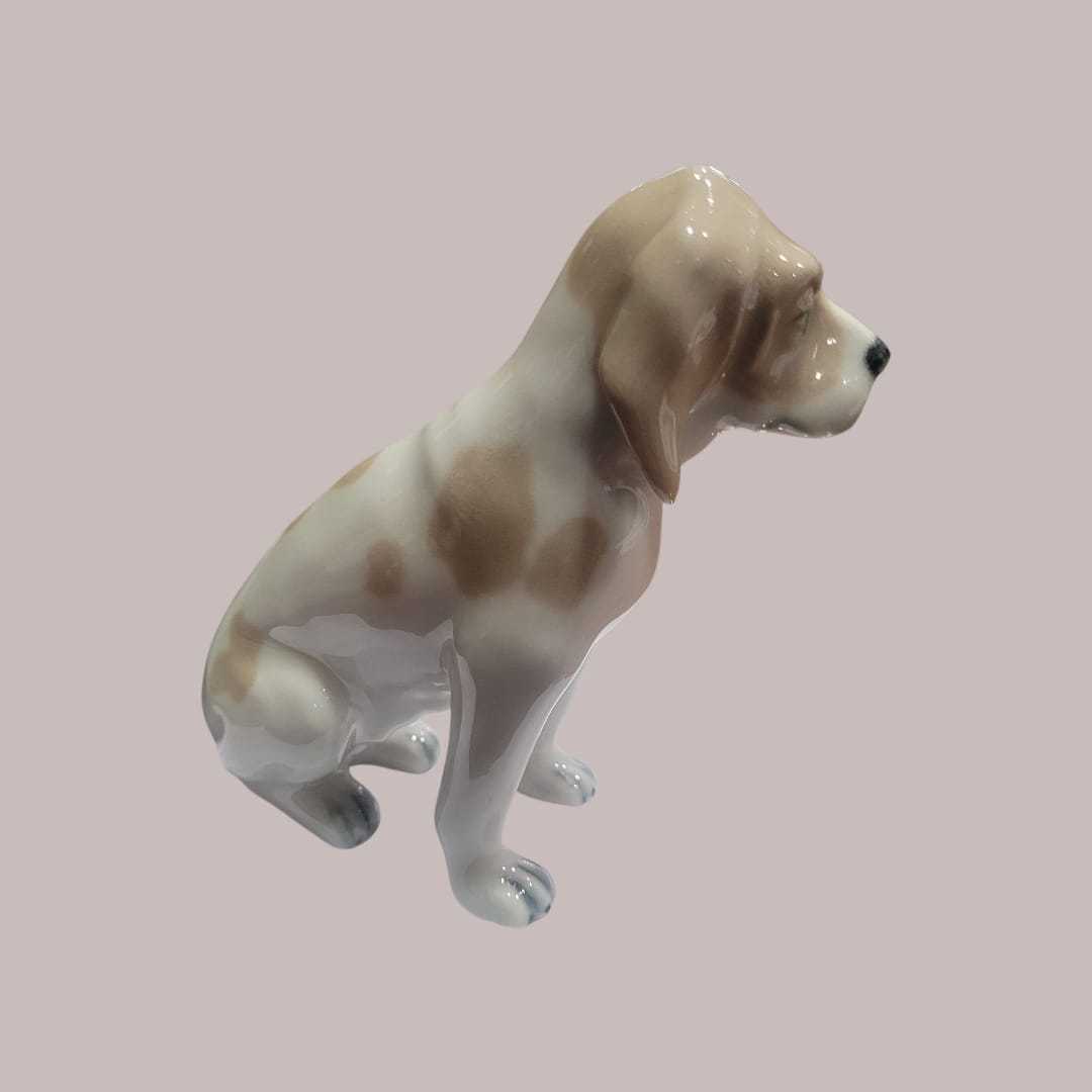 Perro de porcelana Lladró sentado en acabado brillante, figura decorativa ideal para coleccionistas y amantes de la decoración clásica.