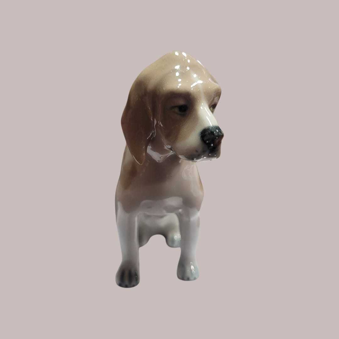 Perro de porcelana Lladró sentado en acabado brillante, figura decorativa ideal para coleccionistas y amantes de la decoración elegante.