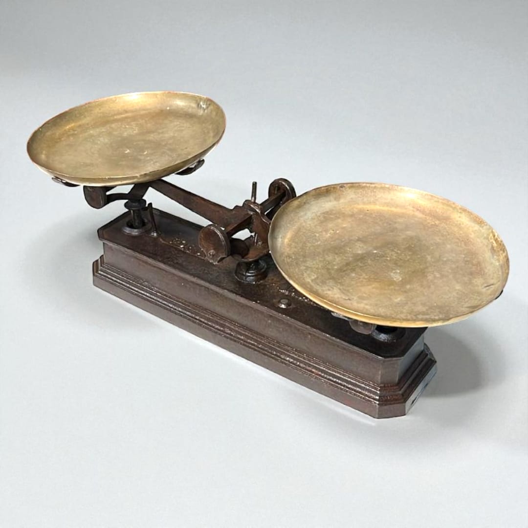 Balanza de hierro con platos metálicos vintage vista lateral.
