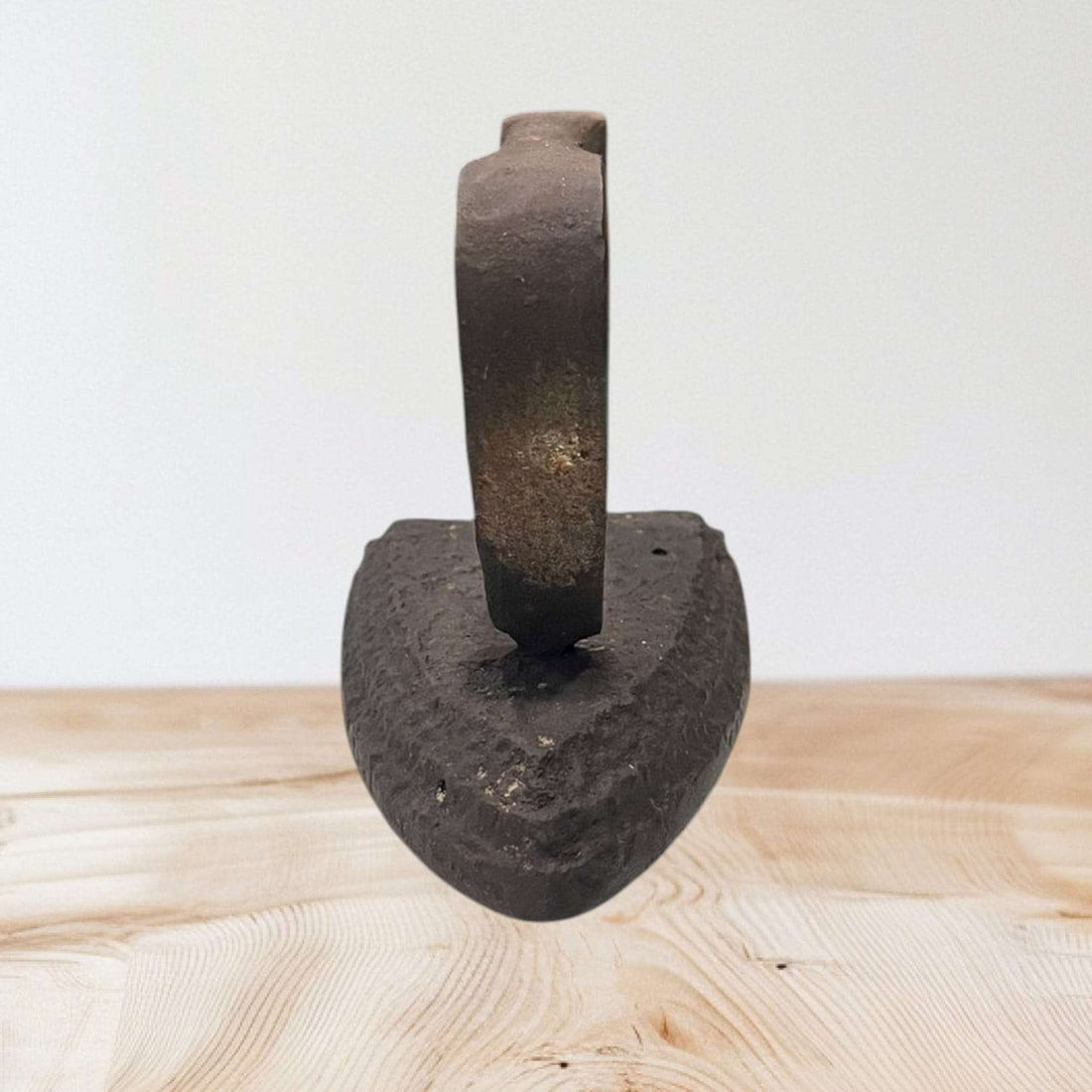 Plancha antigua de hierro fundido con mango curvo, ideal para decoración vintage en hogar o colección histórica.