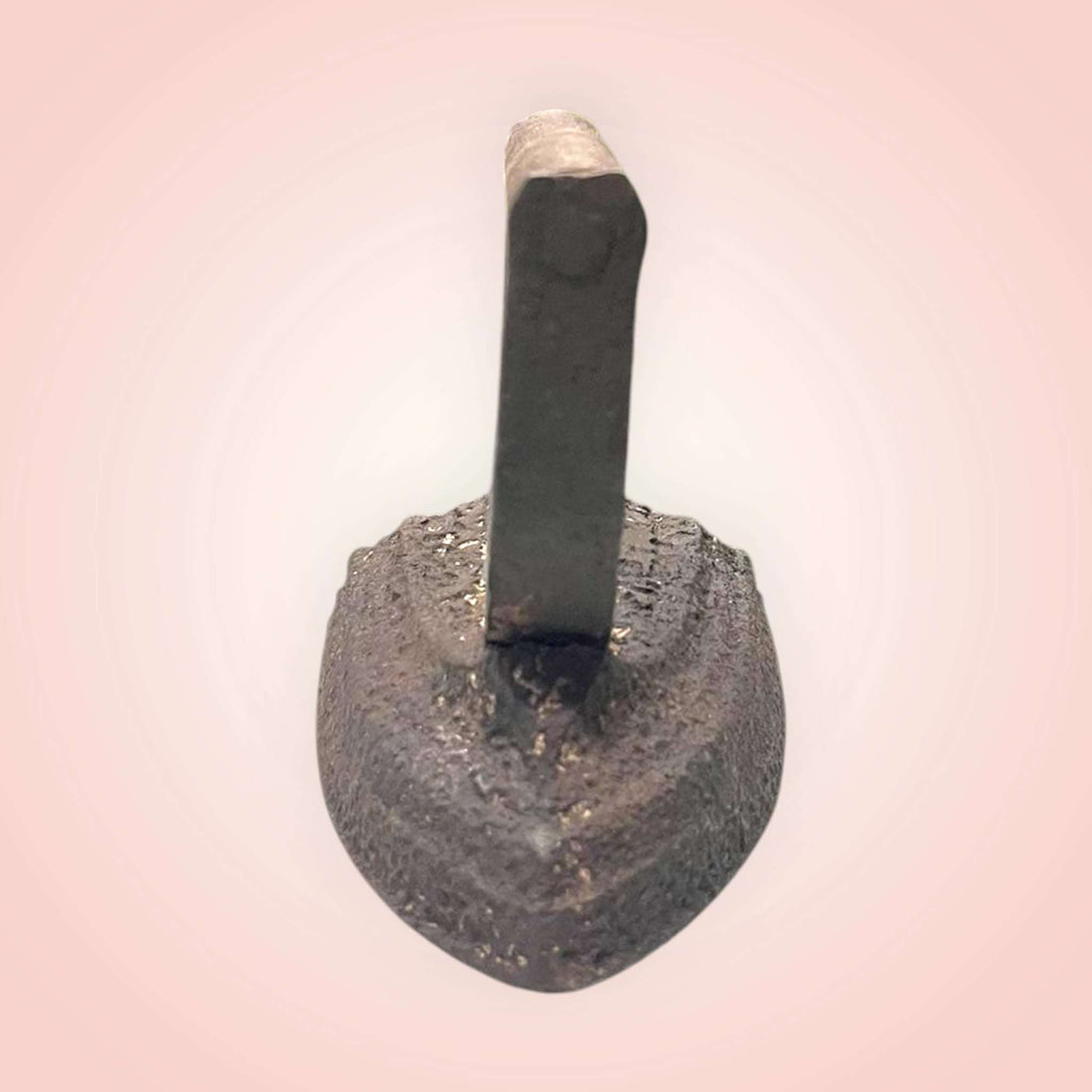 Plancha antigua de hierro con asa fija en vista frontal.