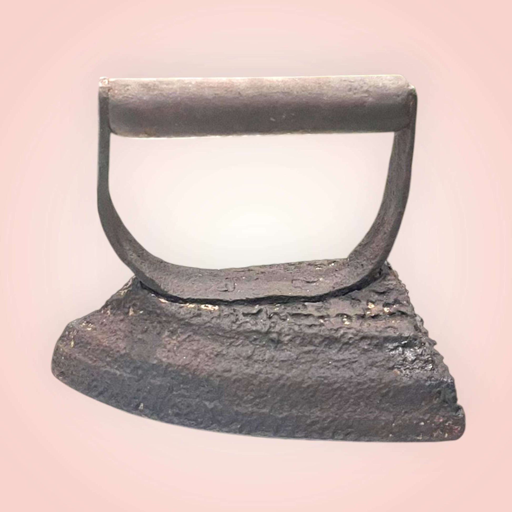 Plancha antigua de hierro con asa fija en vista frontal.