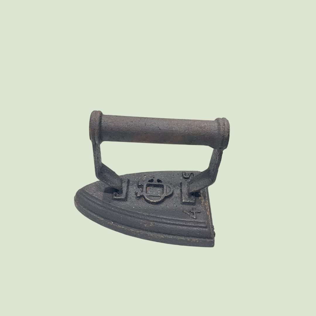 Plancha antigua de hierro fundido con detalles visibles en la base, pieza única decorativa para ambientes rústicos o colecciones históricas.