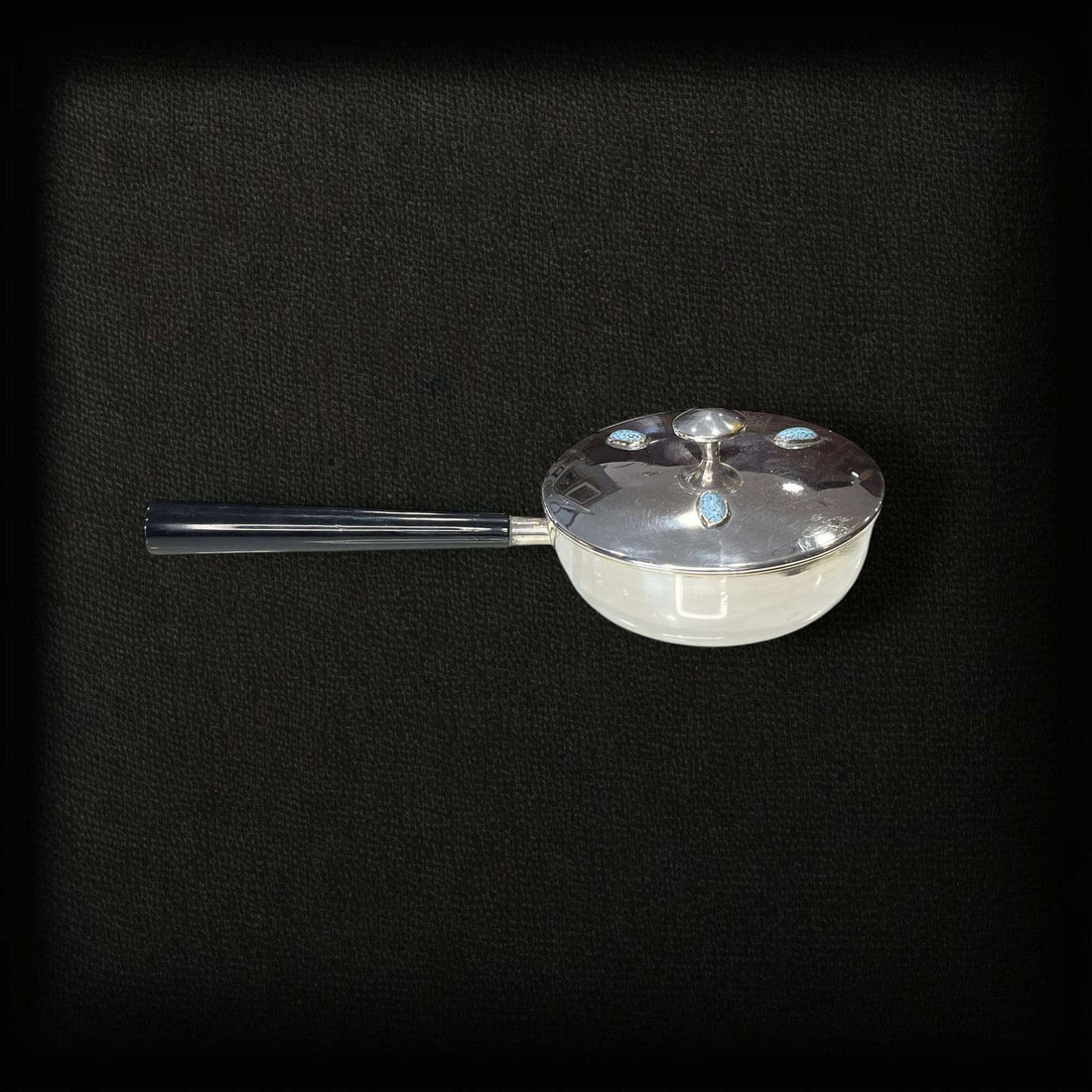 Portafritos de metal plateado con mango y tapa con turquesas.