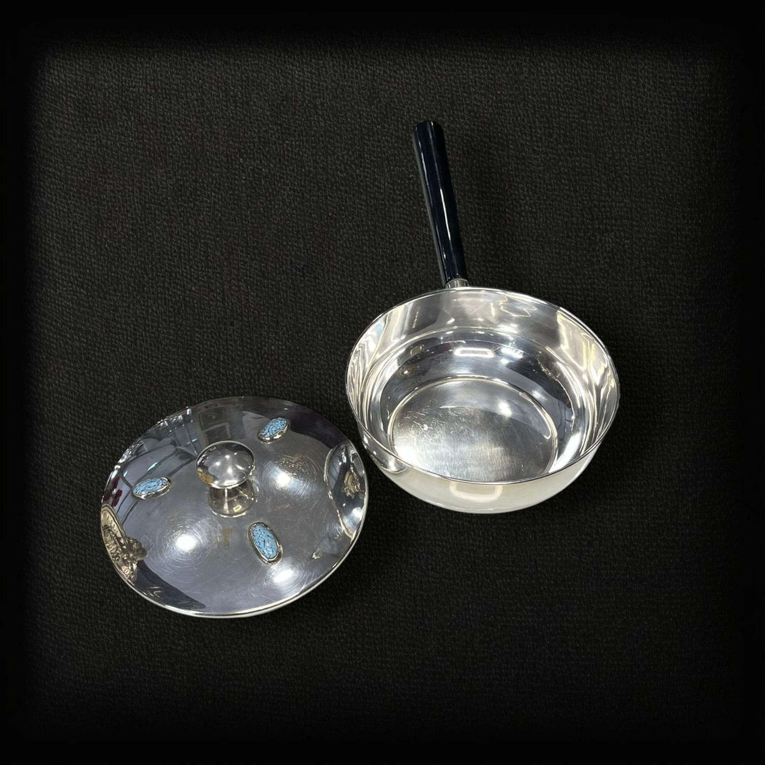 Portafritos de metal plateado con mango y tapa con turquesas.