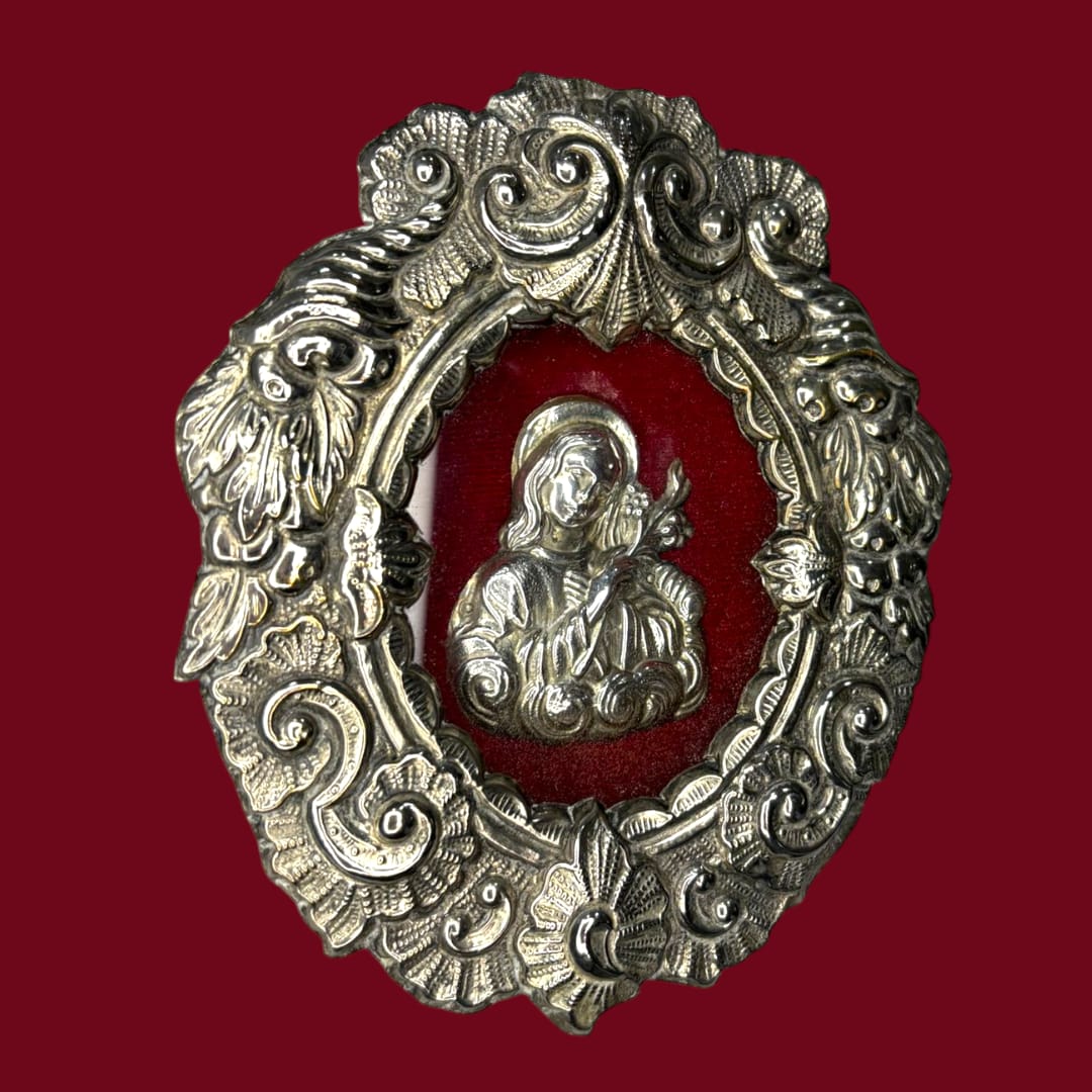 Este Relicario representa a Santa Filomena sosteniendo un lirio o una palma, símbolos universales de pureza, fe y martirio. 