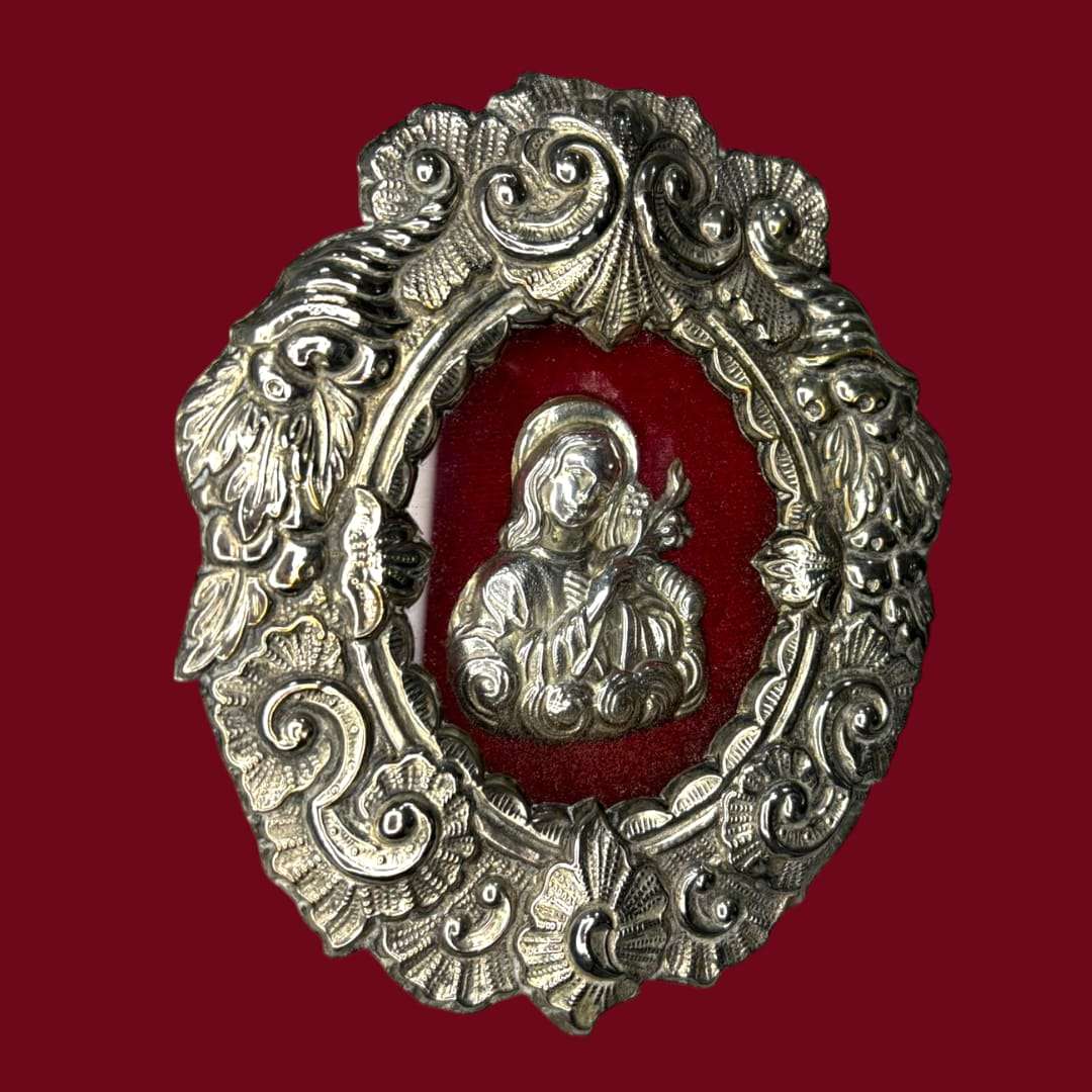 Este Relicario representa a Santa Filomena sosteniendo un lirio o una palma, símbolos universales de pureza, fe y martirio. 