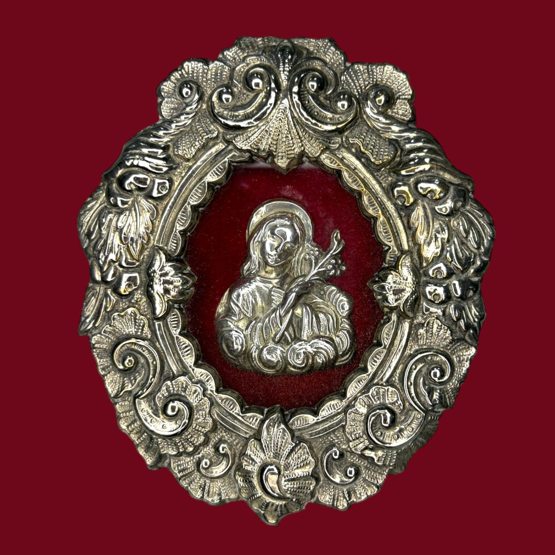 Este Relicario representa a Santa Filomena sosteniendo un lirio o una palma, símbolos universales de pureza, fe y martirio. 